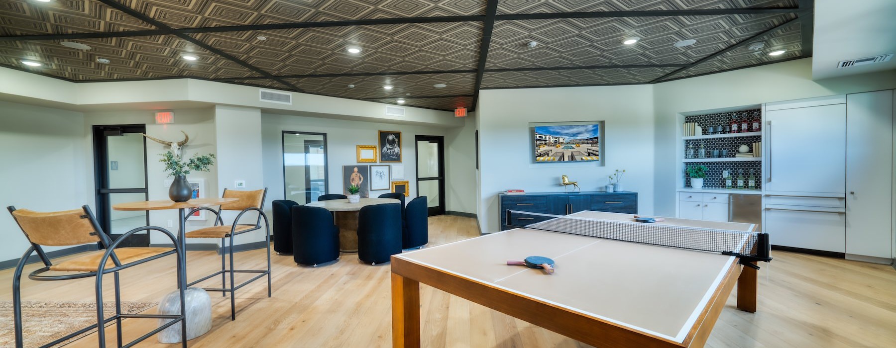 a clubroom with a ping pong table, chairs and tables