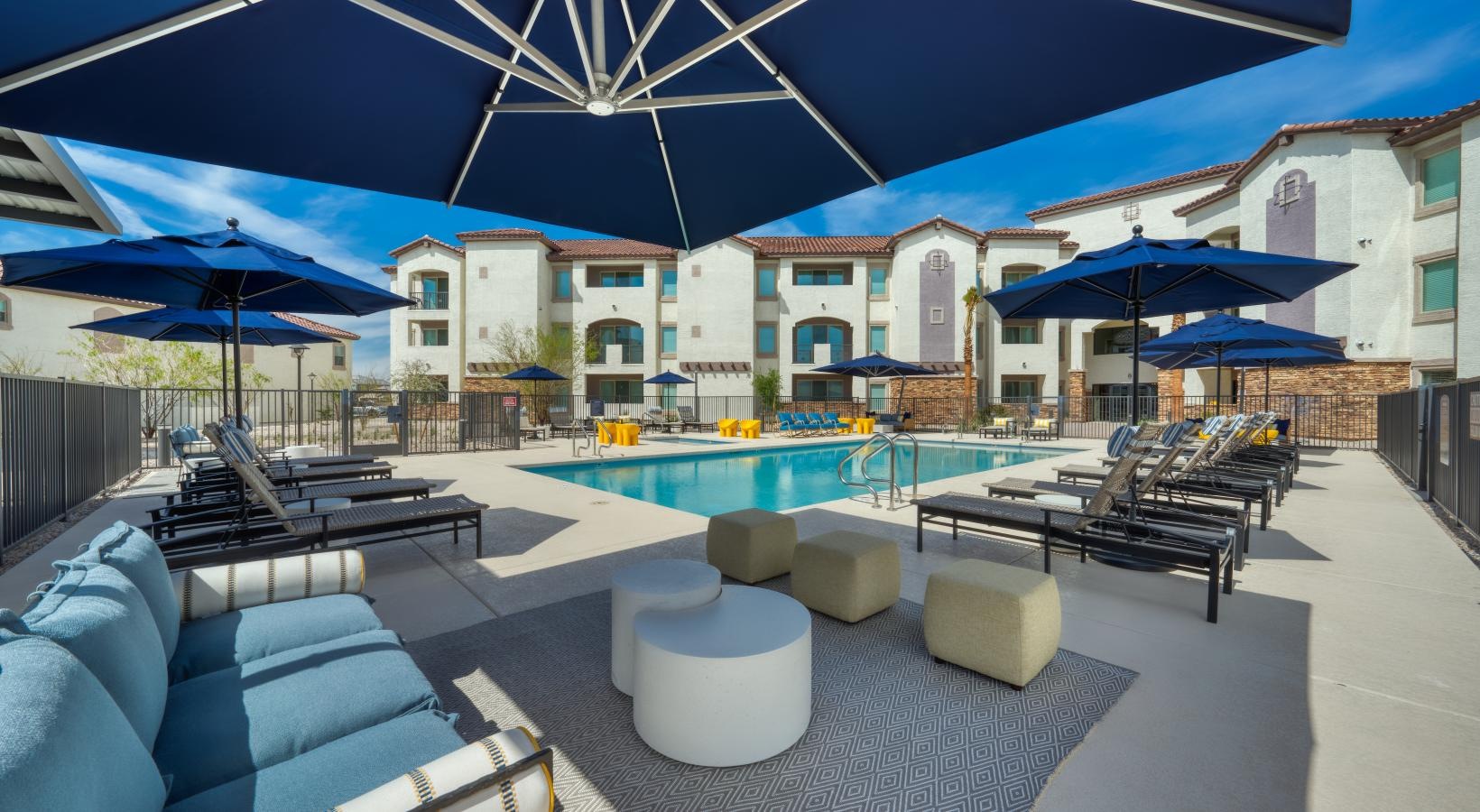 Resort-style swimming pool a pool with lounge chairs and umbrellas